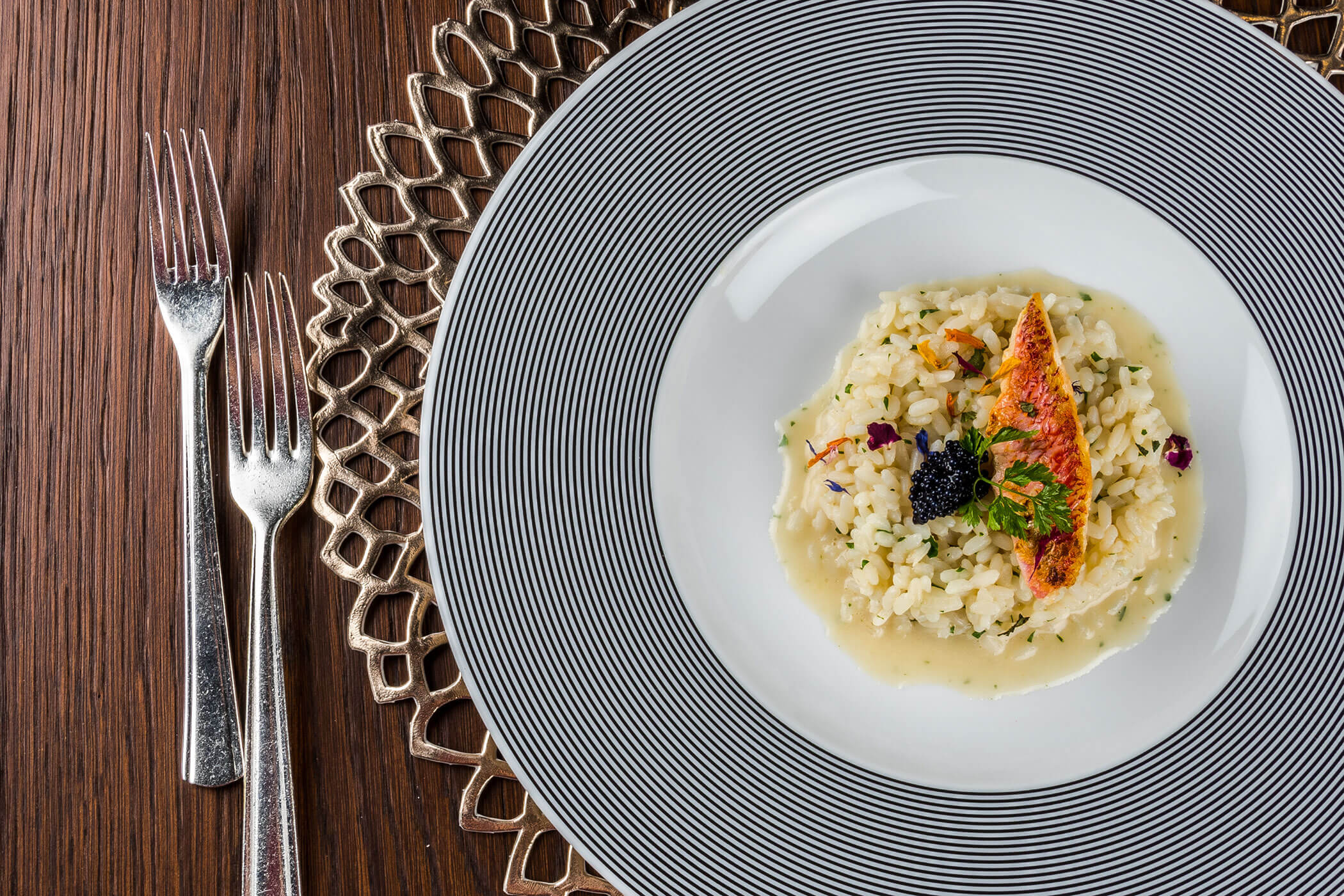 Risotto mit einem Stück Fisch darauf - Posta Zirm
