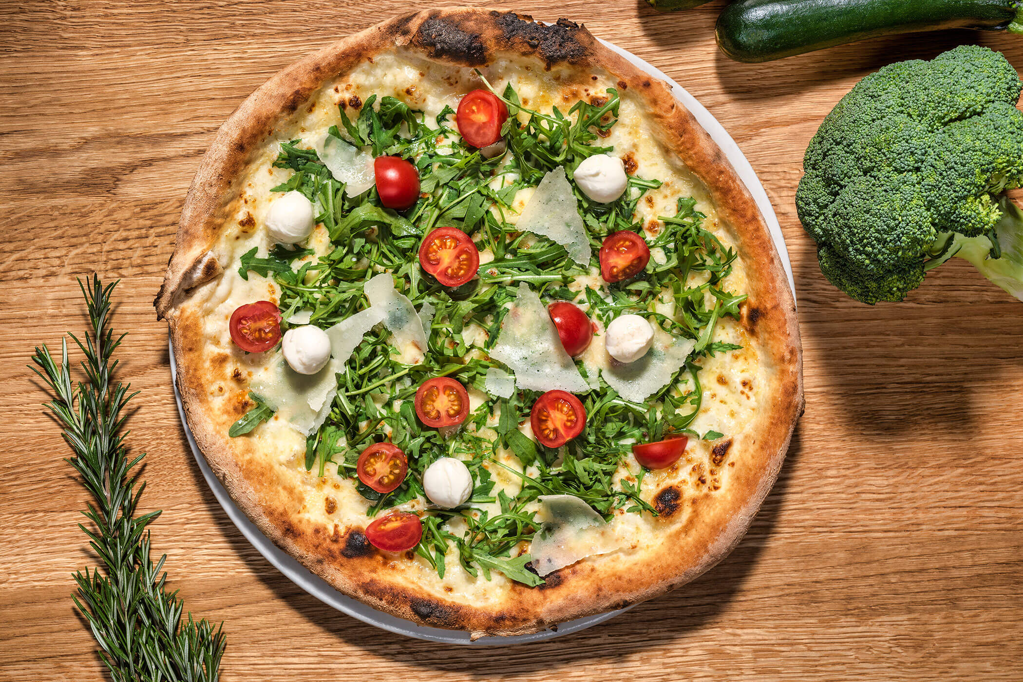 Pizza mit Rucola, Parmesan, Mozzarella und Cocktailtomaten - Posta Zirm