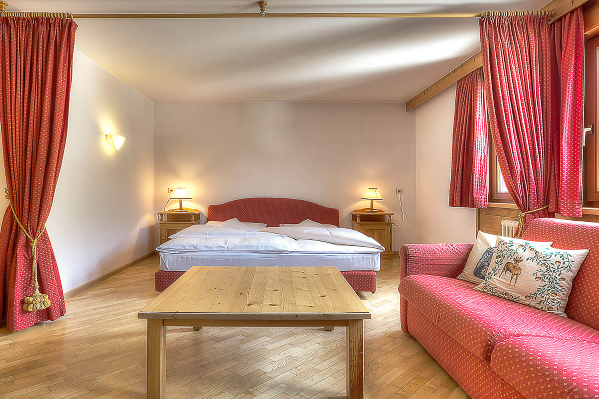 Sofa mit Doppelbett und kleinem Holztisch in der Ferienwohnung Boé - Posta Zirm