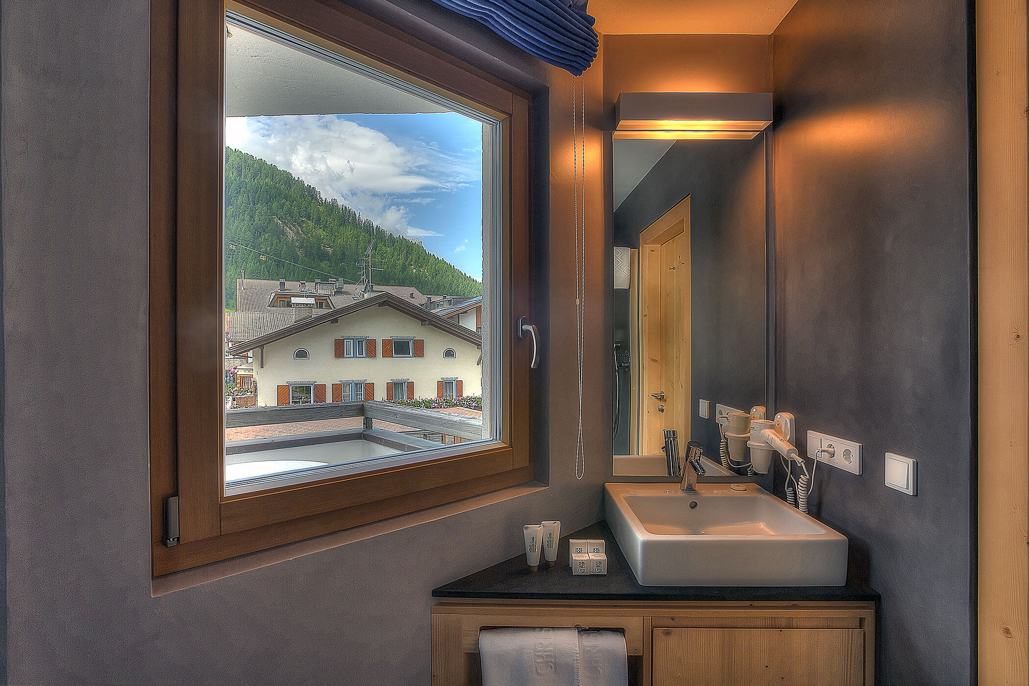 Badezimmer mit großem Fenster in der Ferienwohnung Ciampac - Posta Zirm