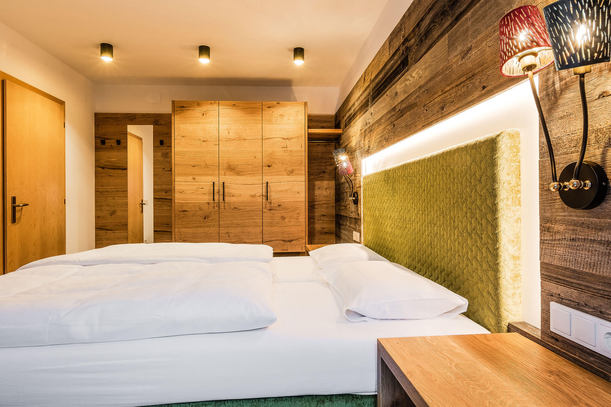 Schlafzimmer mit Holzschrank in der Ferienwohnung Colalto - Posta Zirm