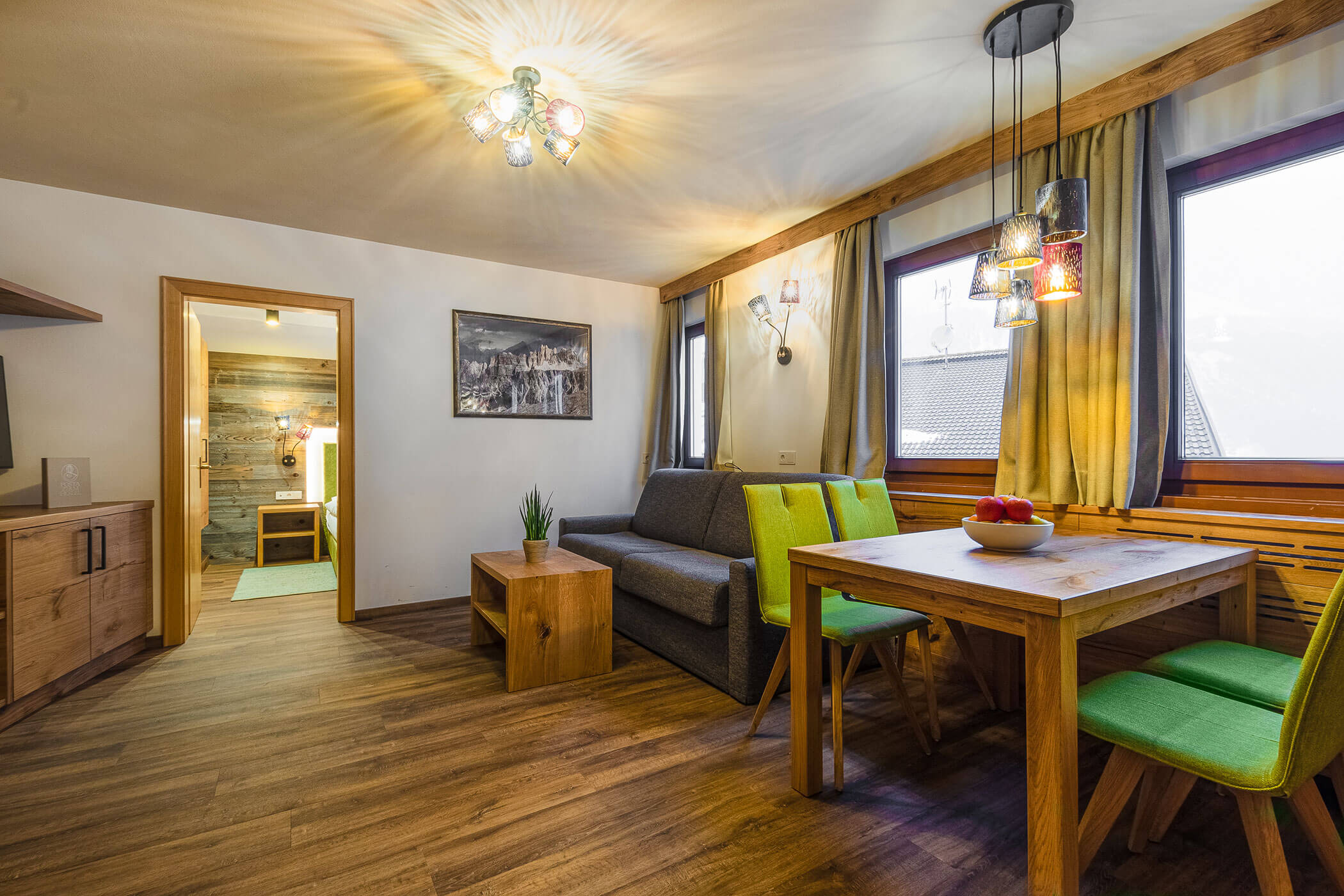 Wohn- und Esszimmer mit Sofa und Esstisch in der Ferienwohnung Colalto - Posta Zirm
