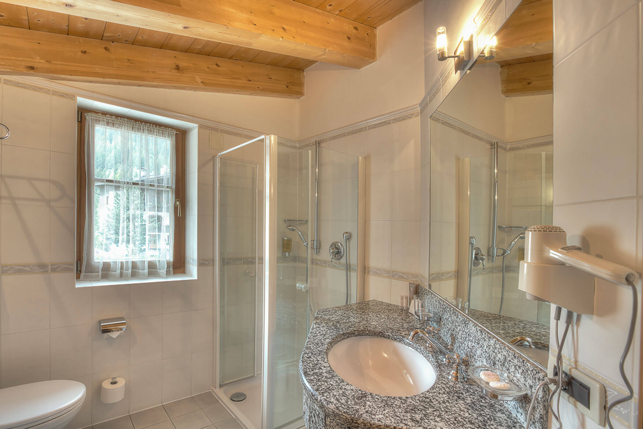 Badezimmer mit Dusche, WC und Waschbecken in der Ferienwohnung Gran Val - Posta Zirm