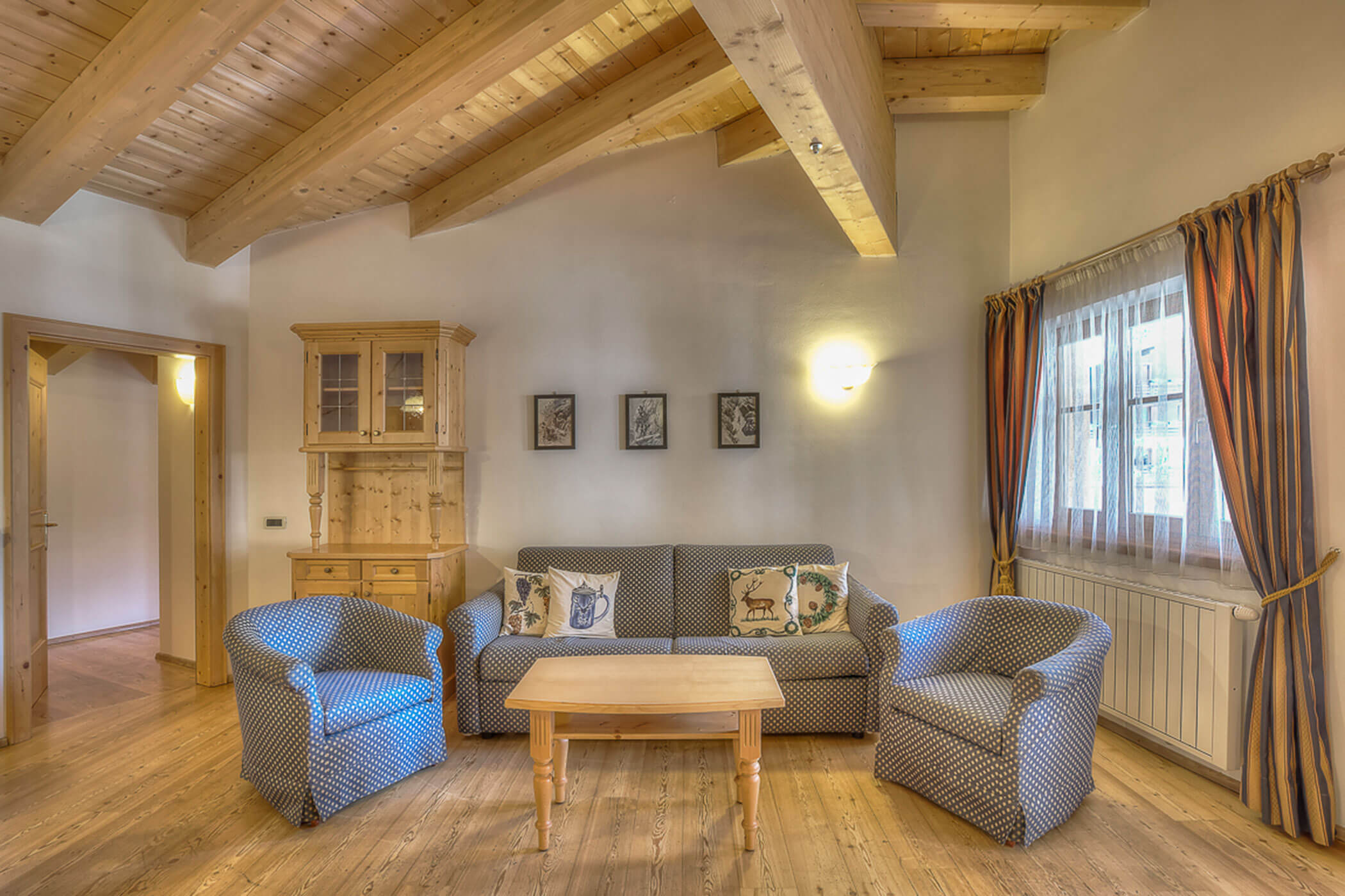 Wohnzimmer mit Sofa und Sessel in der Ferienwohnung Gran Val - Posta Zirm