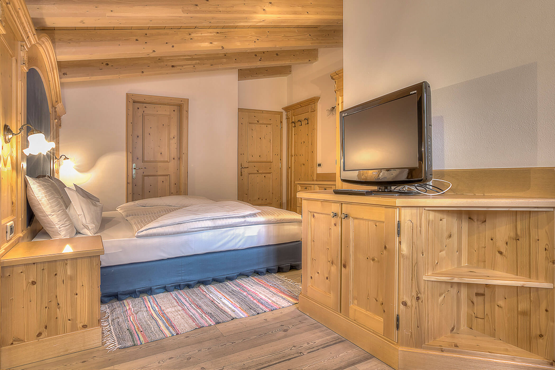 Schlafzimmer mit TV und Doppelbett in der Ferienwohnung Rütort - Posta Zirm