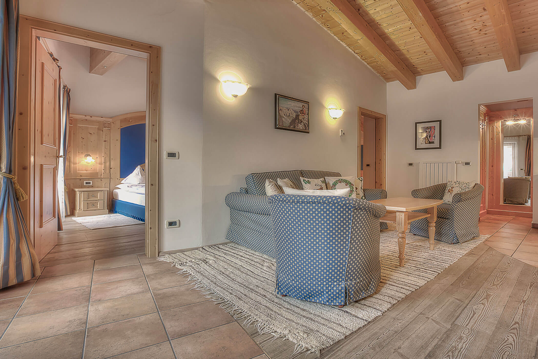 Wohnzimmer mit Sofa, Sessel und Holztisch in der Ferienwohnung Rütort - Posta Zirm