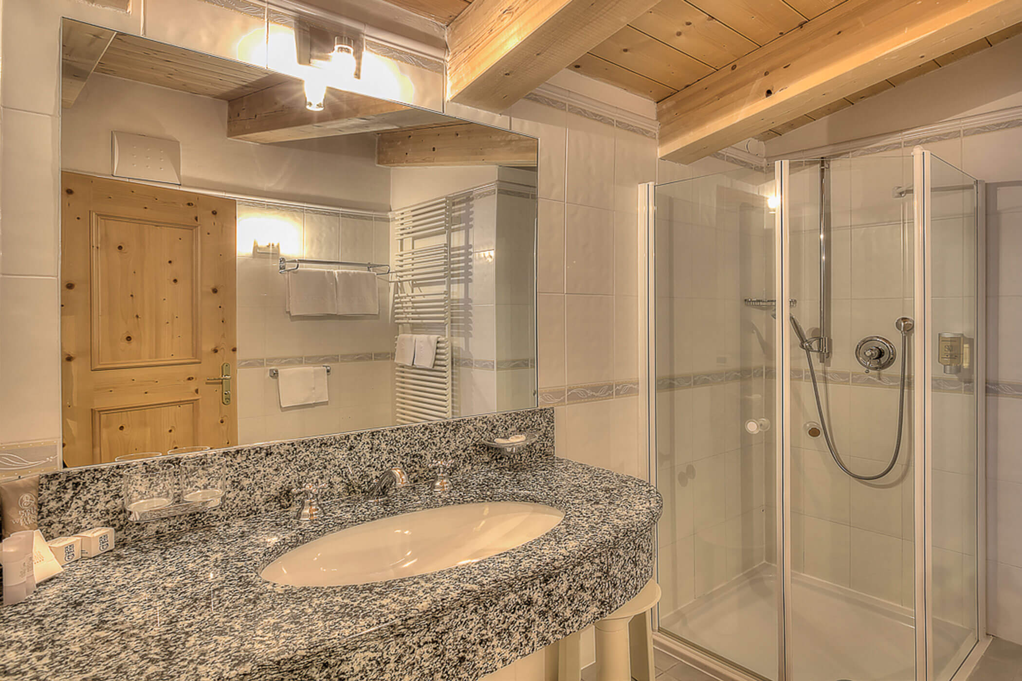 Badezimmer mit Dusche und Waschbecken in der Ferienwohnung Rütort - Posta Zirm