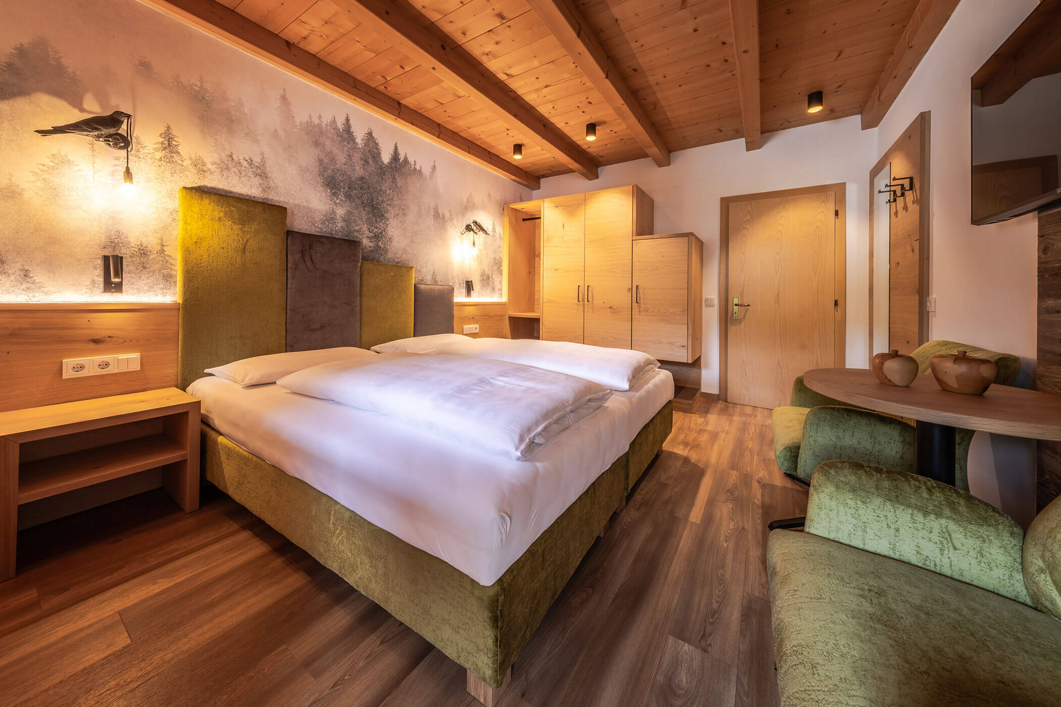 Schlafzimmer mit Doppelbett und Holzschrank in der Ferienwohnung Sassongher - Posta Zirm