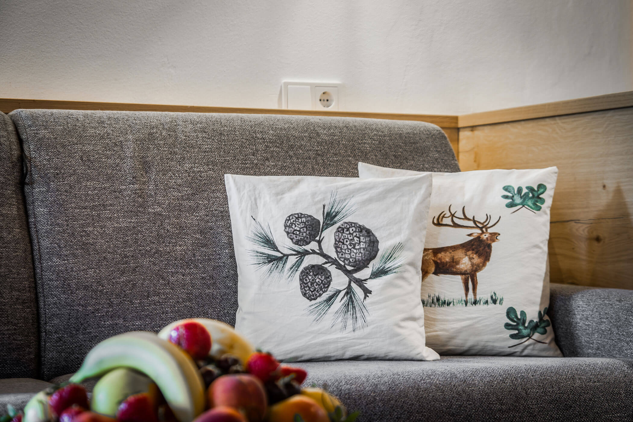 Sofa mit zwei weißen Kissen in der Ferienwohnung Sassongher - Posta Zirm