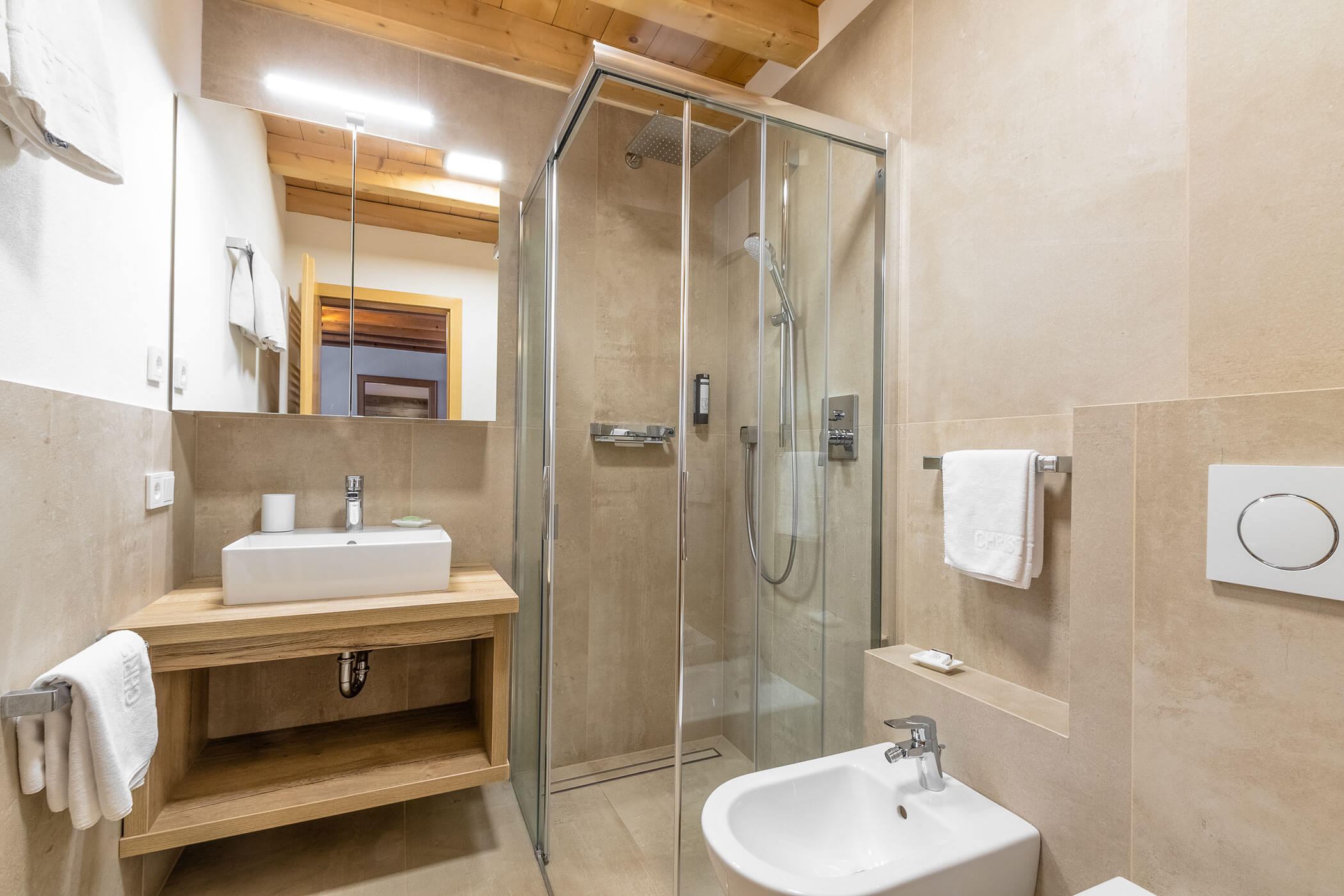 Badezimmer mit Dusche, Waschbecken, Bidet und Spiegel in der Ferienwohnung Settsass - Posta Zirm