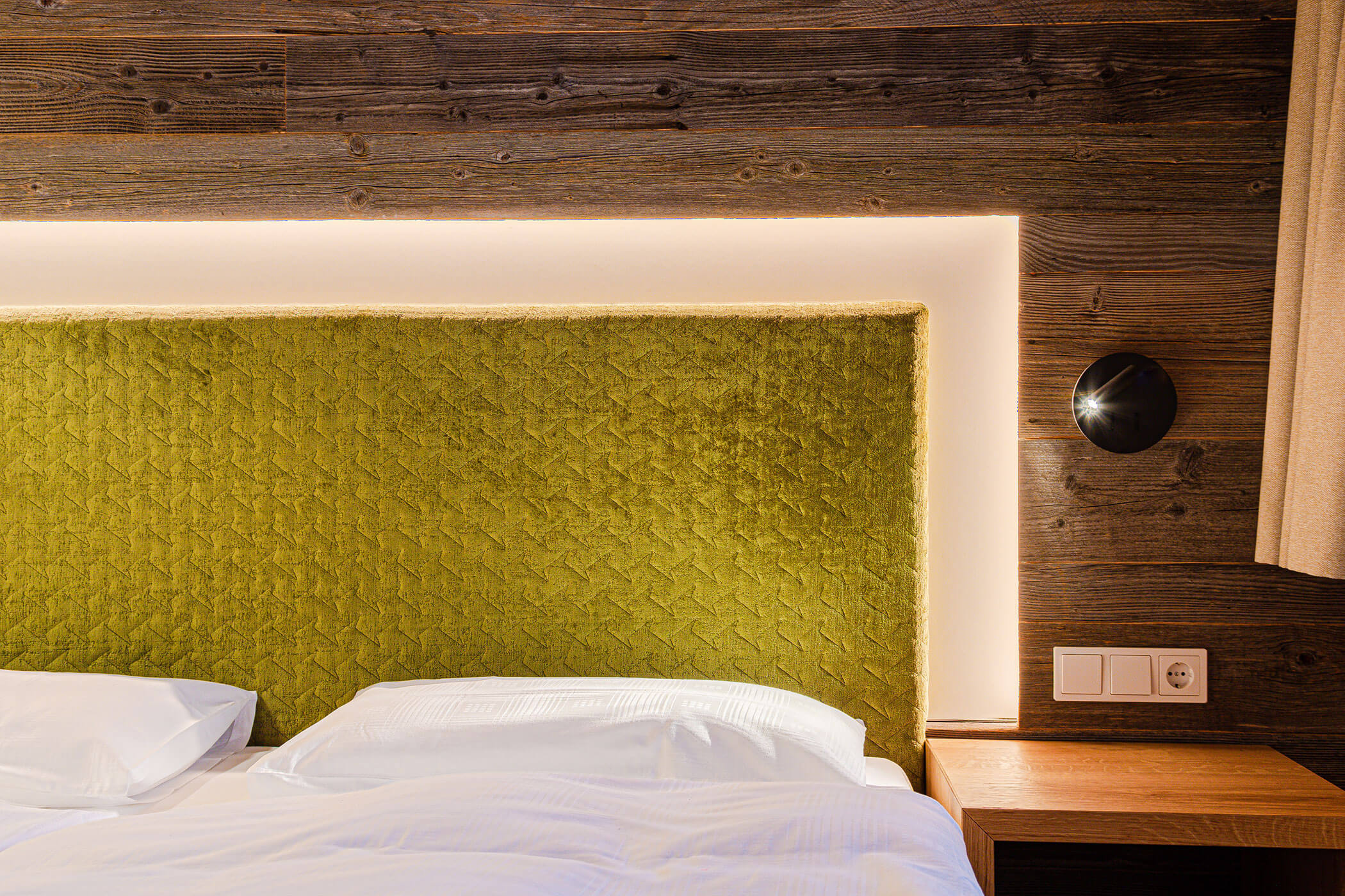 Doppelbett mit Lampe in der Ferienwohnung Settsass - Posta Zirm