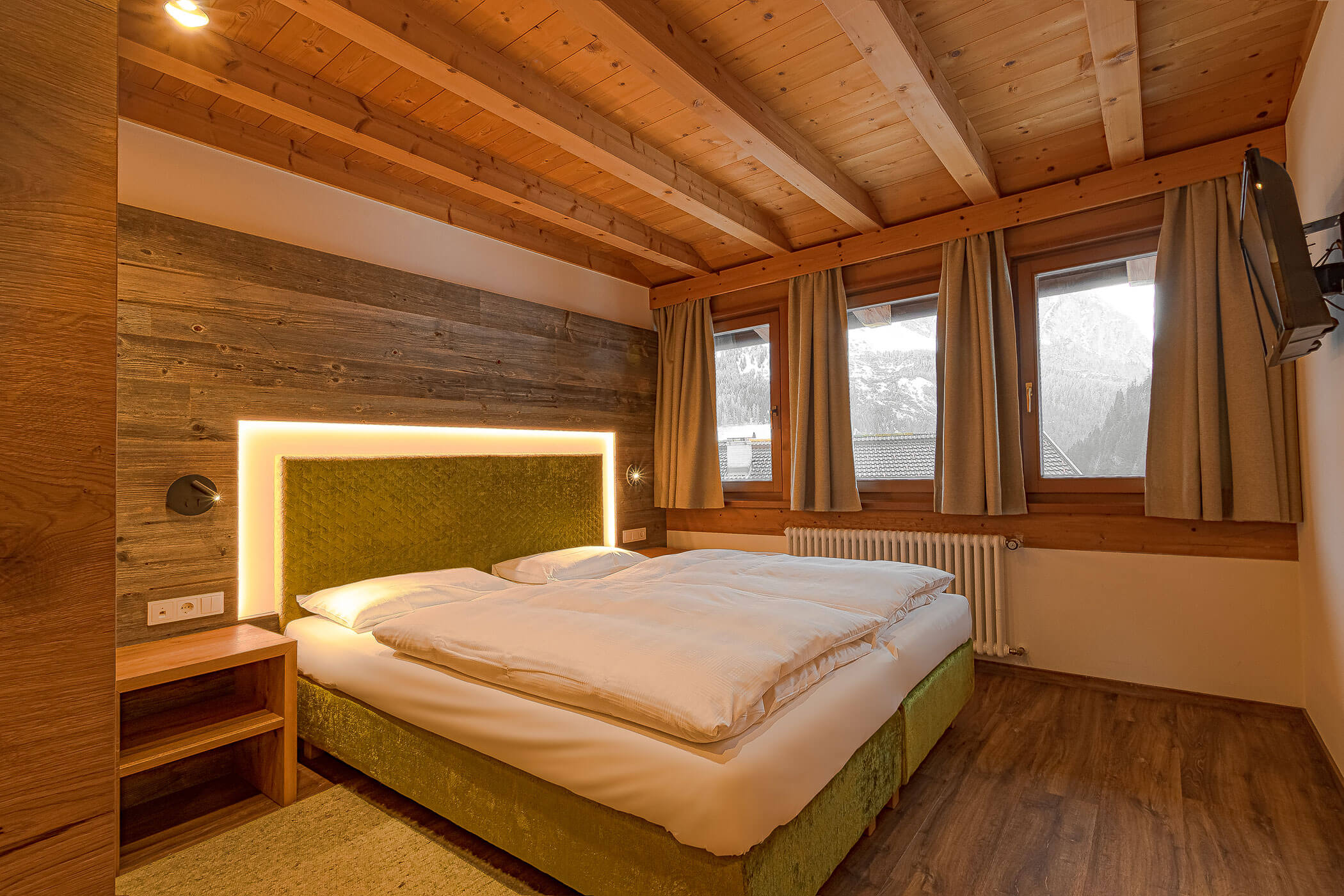 Schlafzimmer mit Doppelbett und TV in der Ferienwohnung Settsass - Posta Zirm