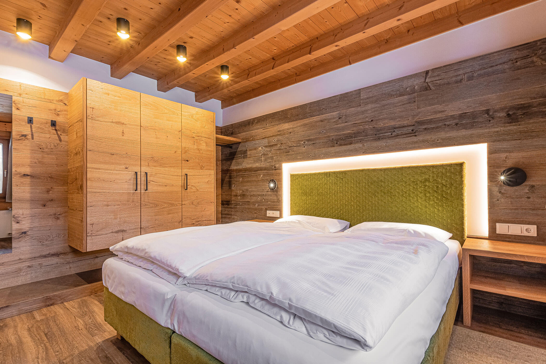 Schlafzimmer mit Holzschrank in der Ferienwohnung Settsass - Posta Zirm