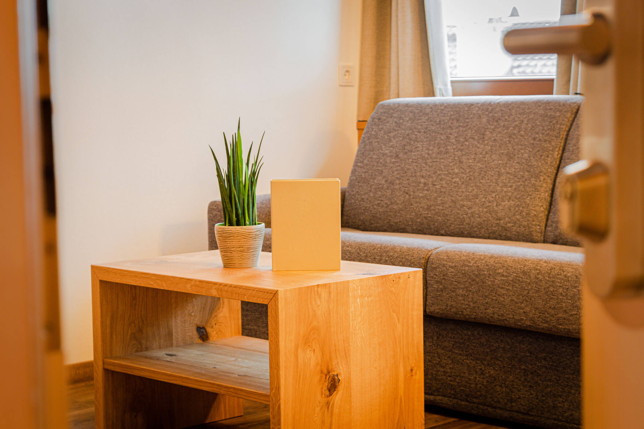 Graues Sofa mit kleinem Holztisch in der Ferienwohnung Settsass - Posta Zirm