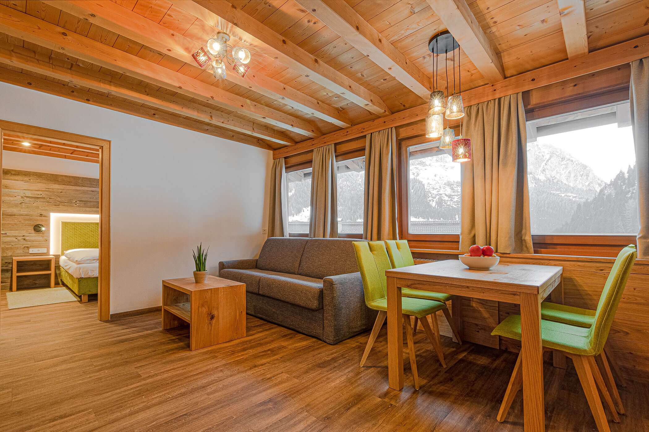 Wohnzimmer mit Sofa und Esstisch in der Ferienwohnung Settsass - Posta Zirm